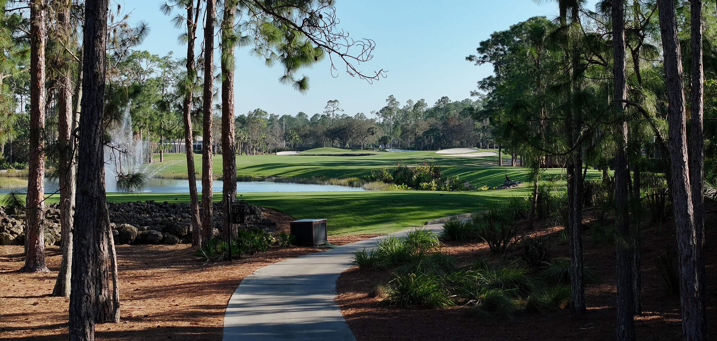 Walkway through wooded area toward golf course