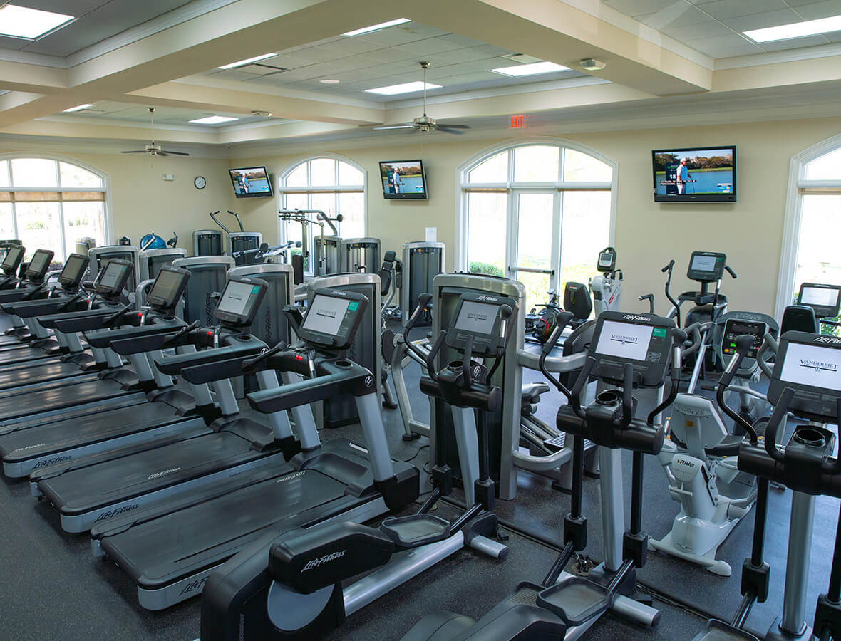 Workout equipment in room with large arched windows